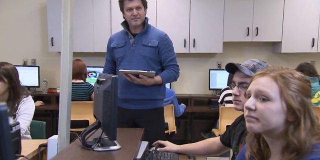 Enseignant qui parle à un groupe d'élèves du secondaire