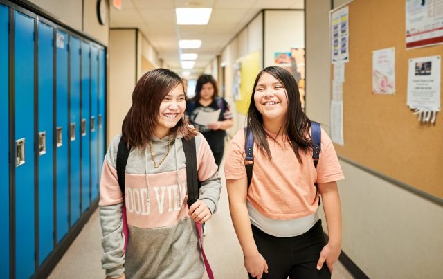 Adolescentes qui rient dans un corridor d'école