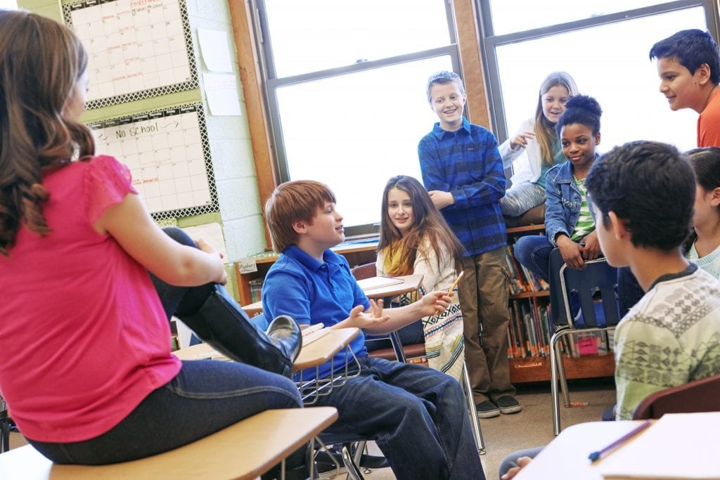 Groupe d'élèves du primaire dans une classe qui discutent