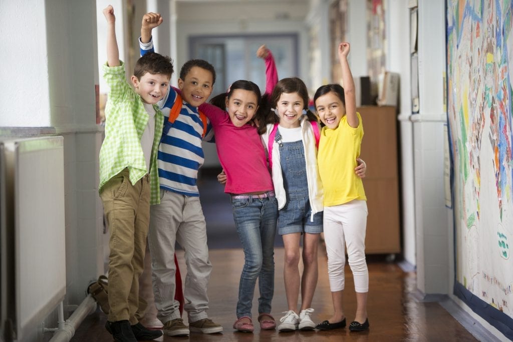 Groupe de jeunes du primaire levant le poing en l'air