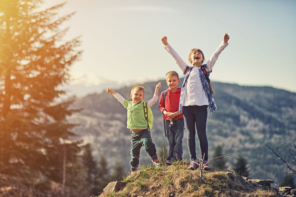 Trois jeunes fiers d'avoir atteint le sommet dela montagne