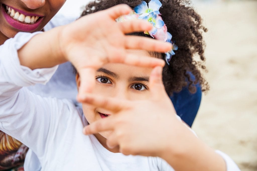 Jeunes filles qui encadre ses yeux avec ses doigts