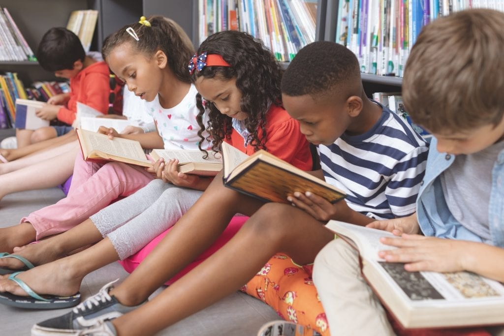 Élèves du primaire qui lisent à la bibliothèque