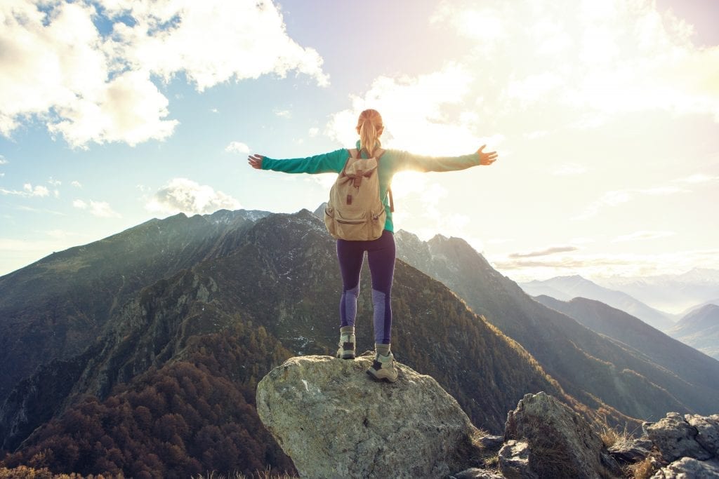 Jeune femme au sommet d'une montagne