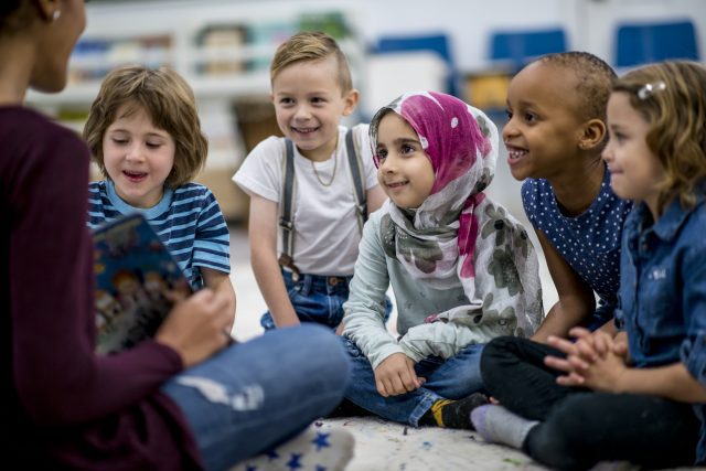 Groupe de jeunes élèves qui écoutent leur enseignante