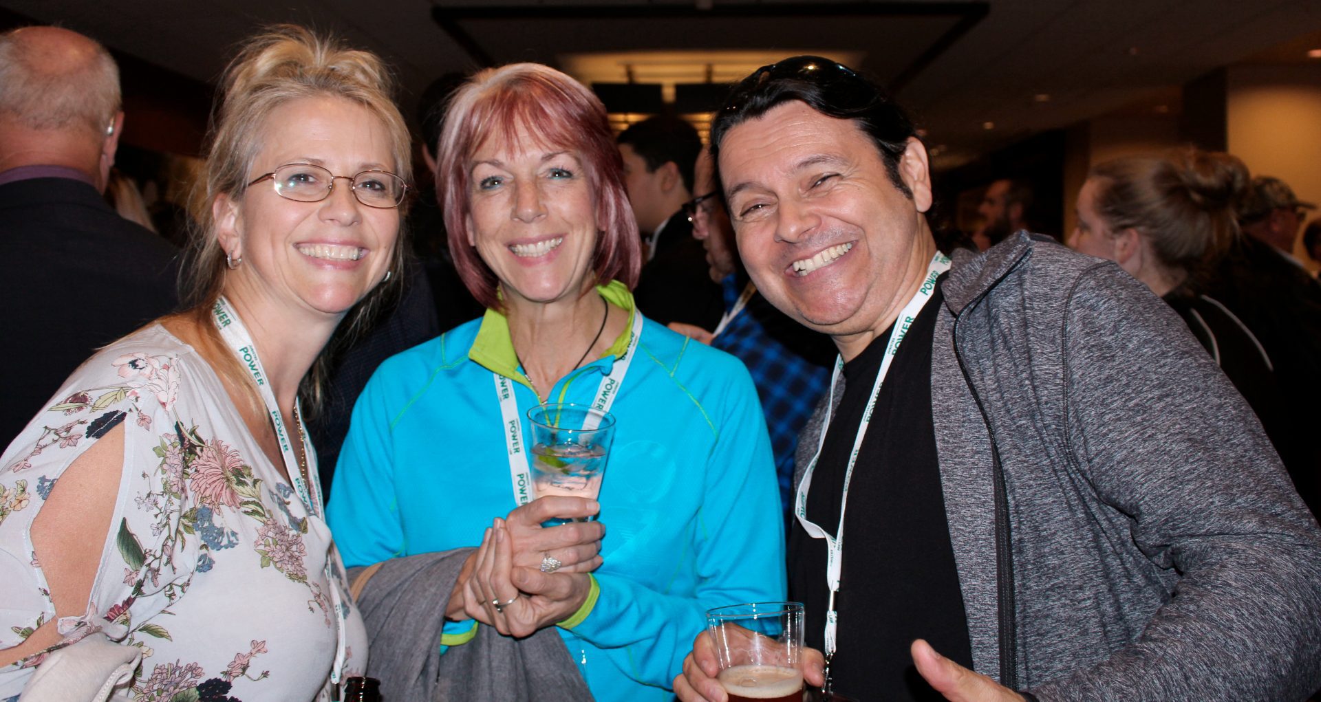 3 congressistes souriants, un verre à la main