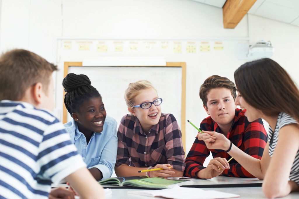 Jeunes du secondaires discutant autour d'une table sur un projet