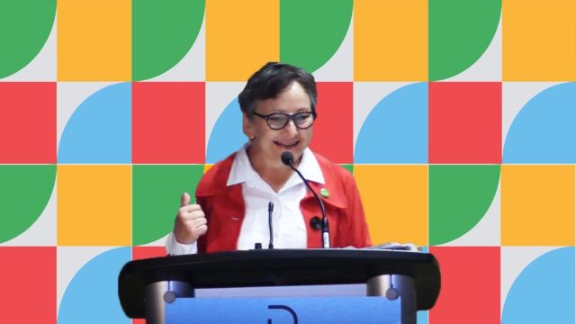 Conférencière en plein discours sur fond aux couleurs de l'ACELF